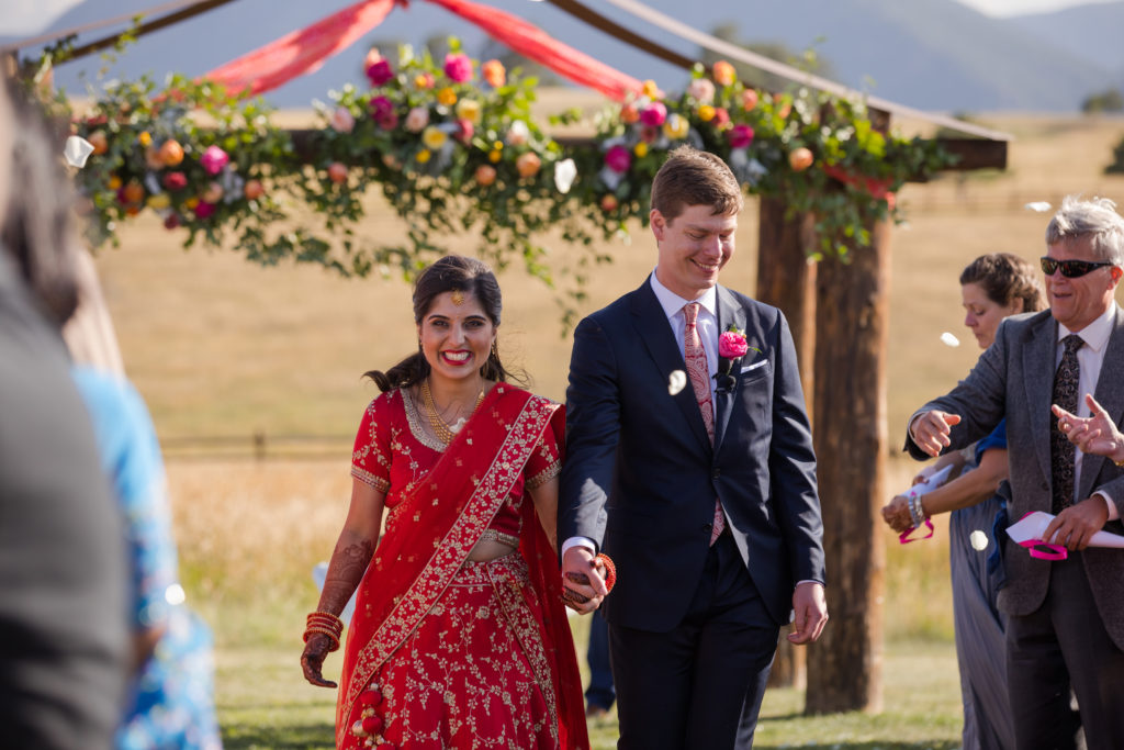 Couple walks down aisle at traditional Spruce Mountain Ranch wedding
