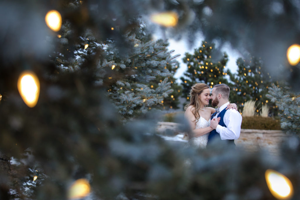 winter wedding couple surrounded by evergreens at classic ranch wedding