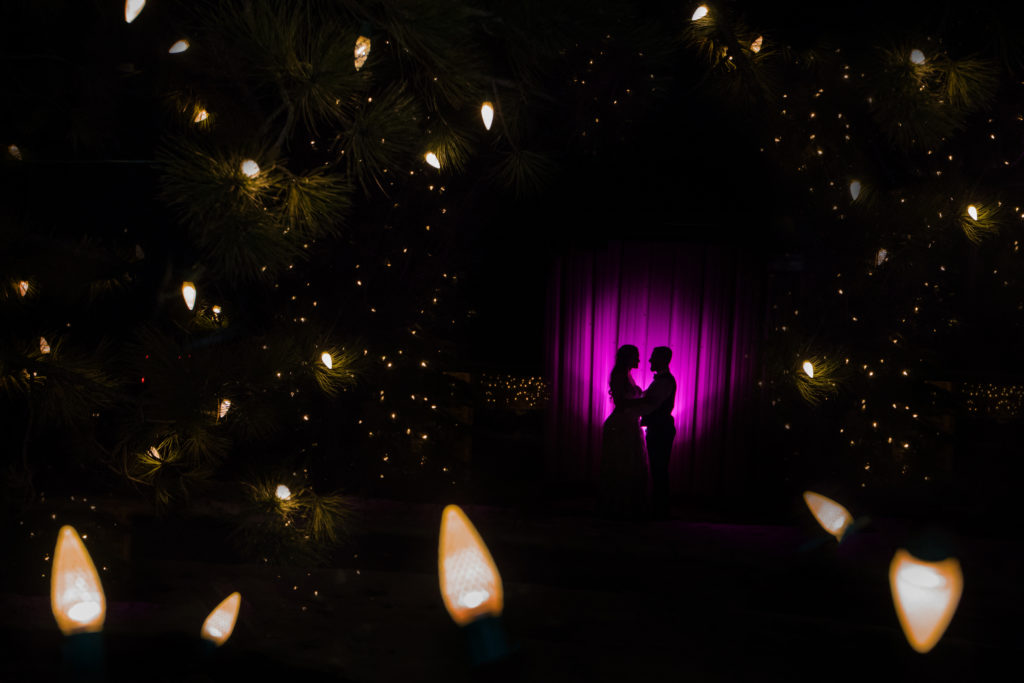 Colorado newlyweds surrounded by Christmas lights at Ponderosa ranch wedding