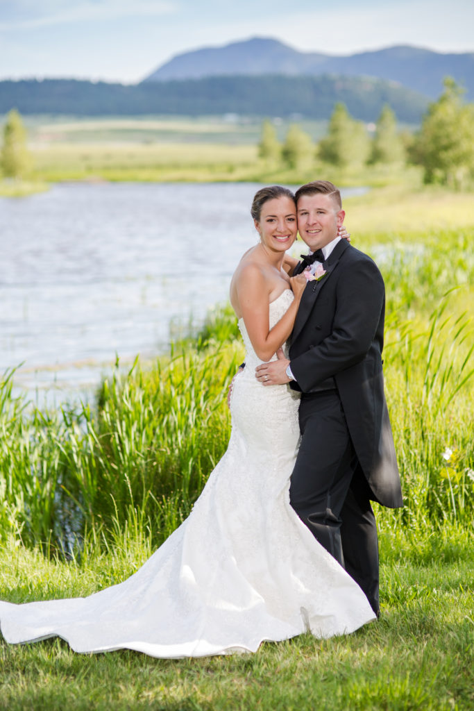 Spring wedding couple by pond at mountain wedding