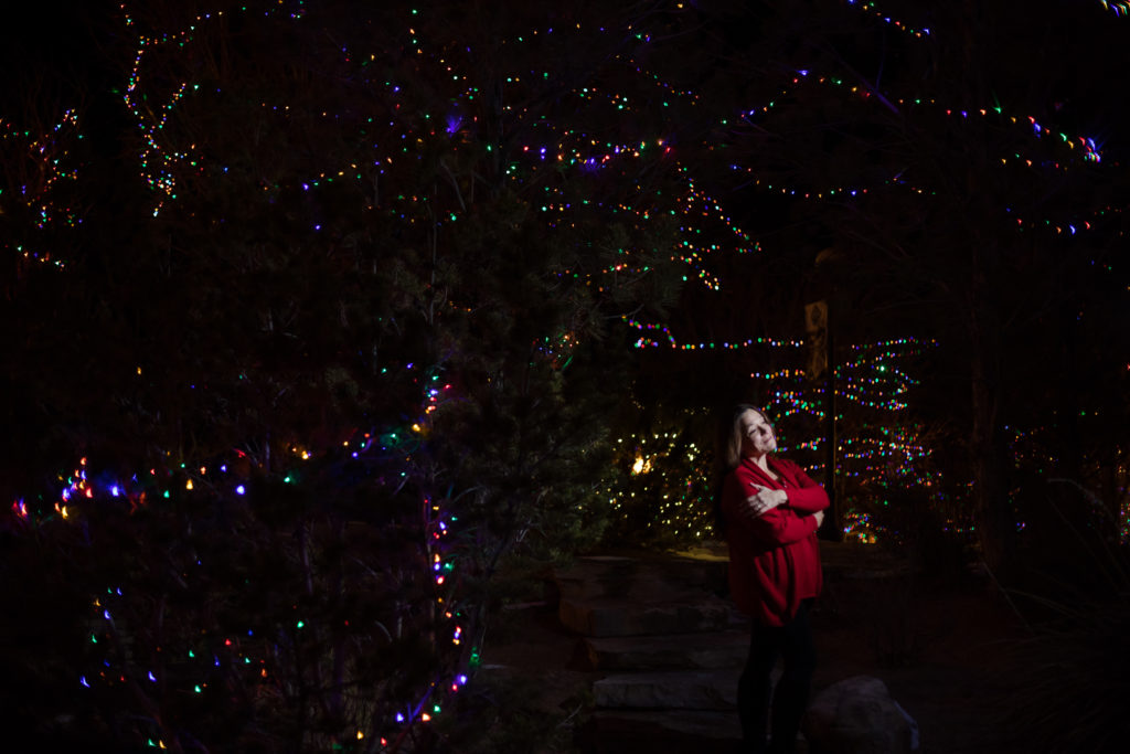 Photographer poses with Christmas Lights at night