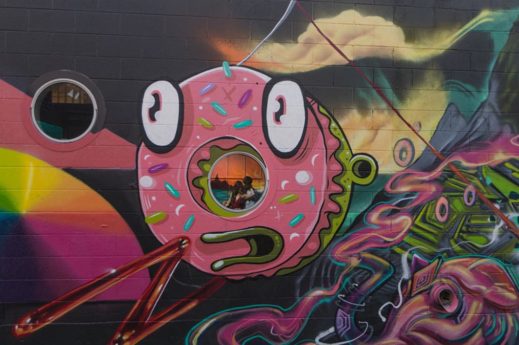 couple reflected in a donut mural in rino arts district engagement session