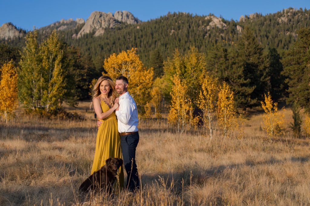 couple in front of rocky mountains with dog