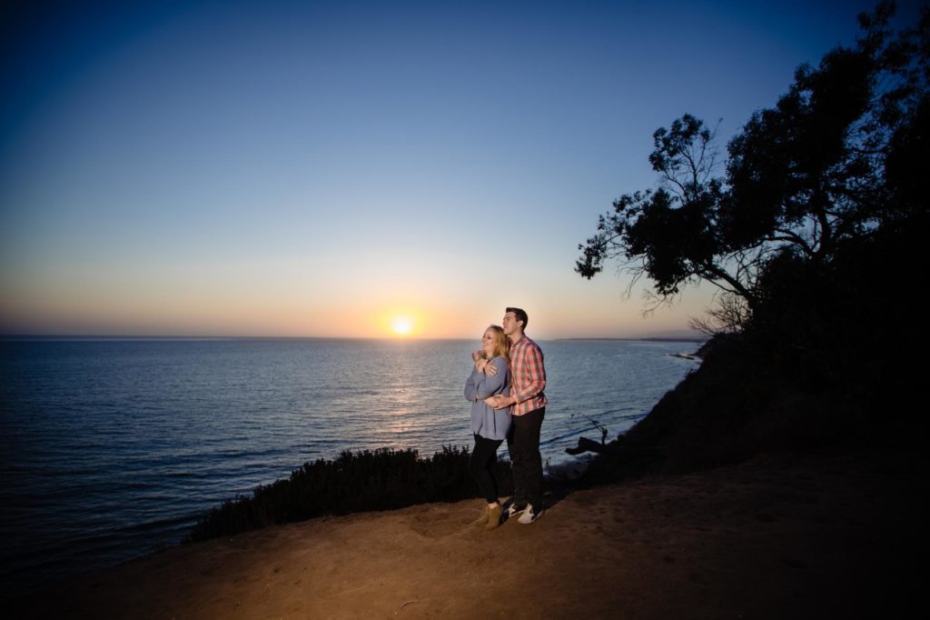 couple stands on cliff for Santa Barbara engagement photographer