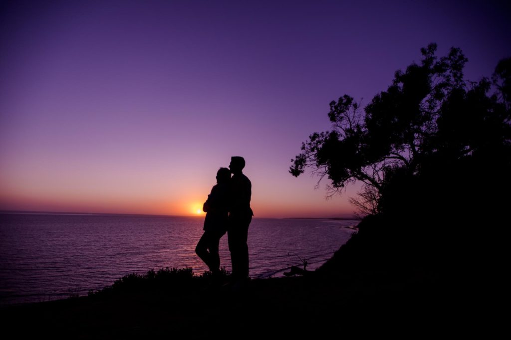 couple stands on cliff for California engagement photographer