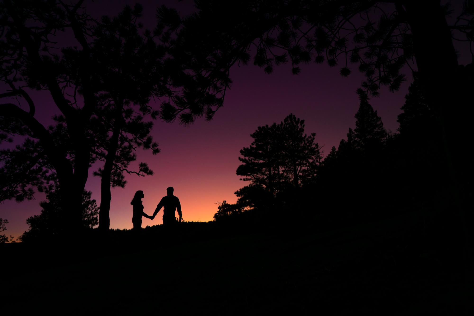 engaged couple in front of mountain sunset