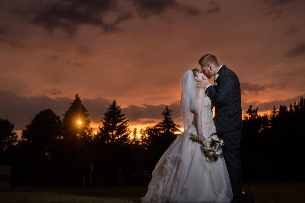 Colorado newlyweds kiss in front of sunset