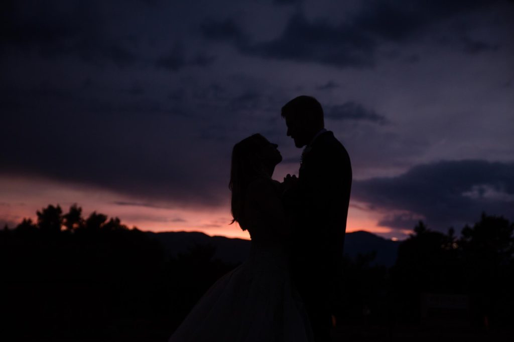 Colorado bride and groom silhouetted against stormy sky