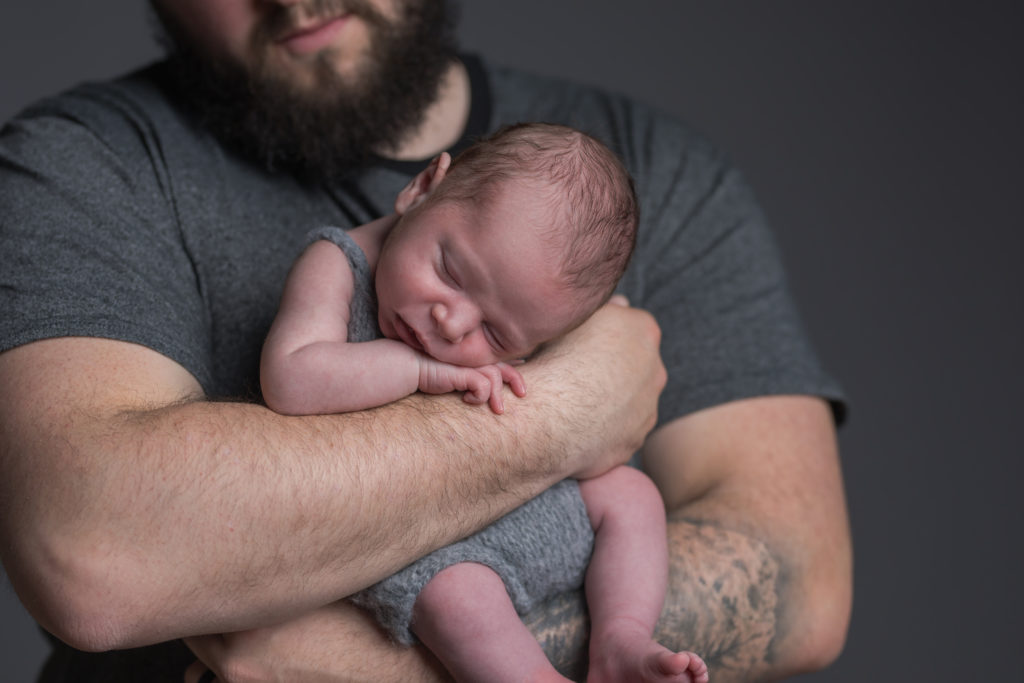 newborn asleep in dad's arms