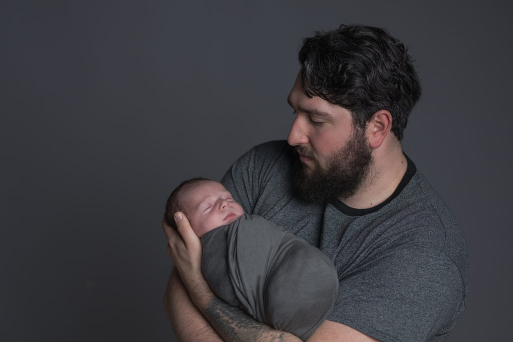 newborn asleep in father's arms