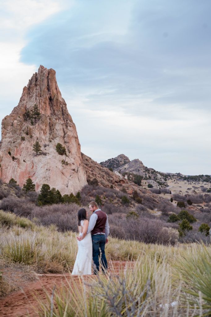 couple holding hands and walking in garden of the gods