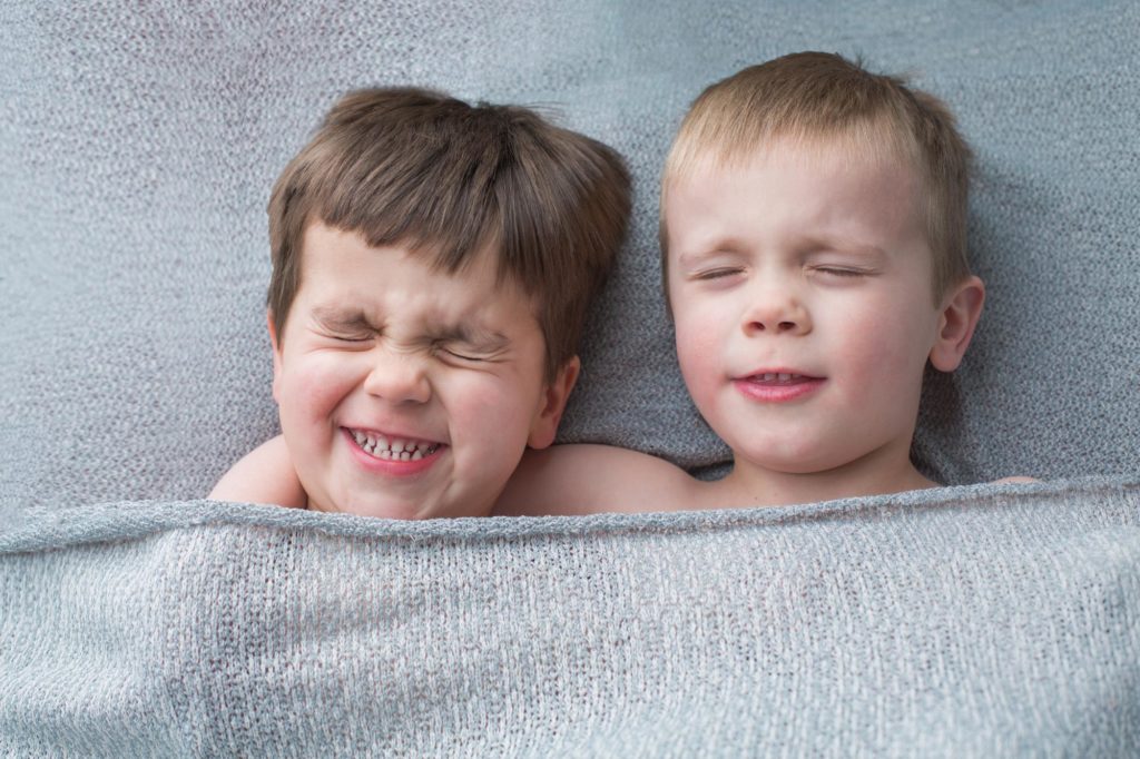 toddler brothers pretending to sleep