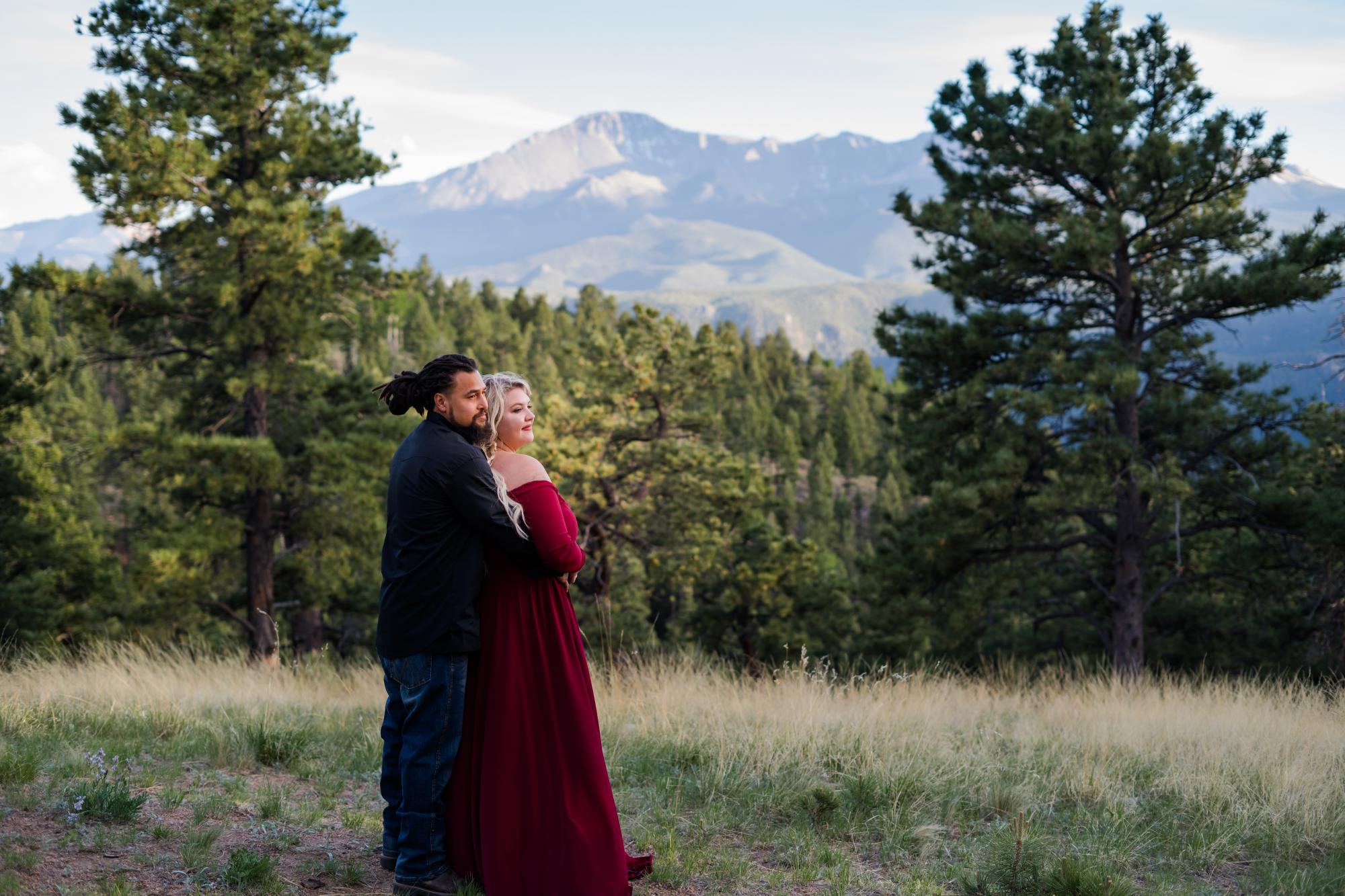 colorado couple holds each other in front of mountains