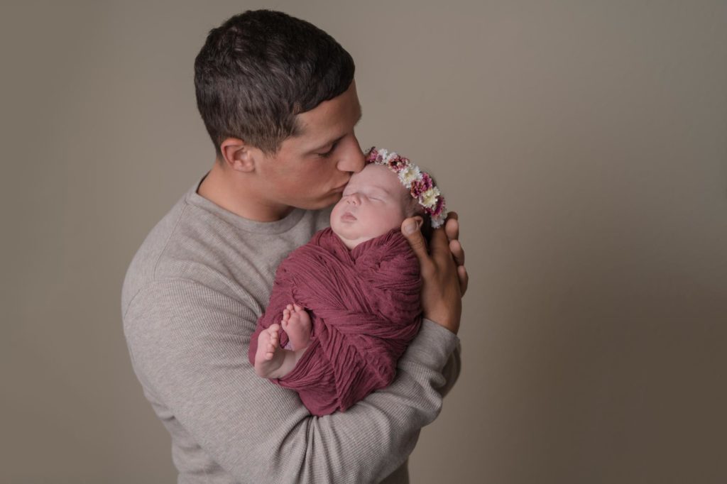 Military dad holds newborn baby