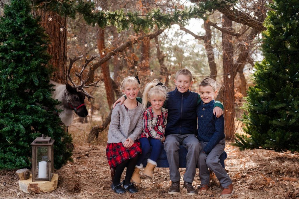 children pose with reindeer
