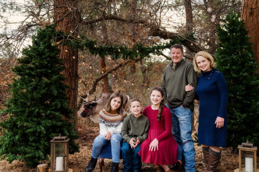 family poses for reideer holiday photo session