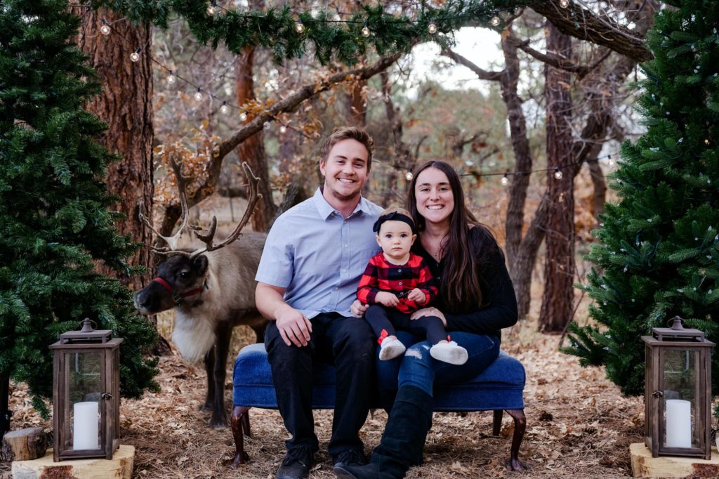 Small family poses for reideer holiday photo session