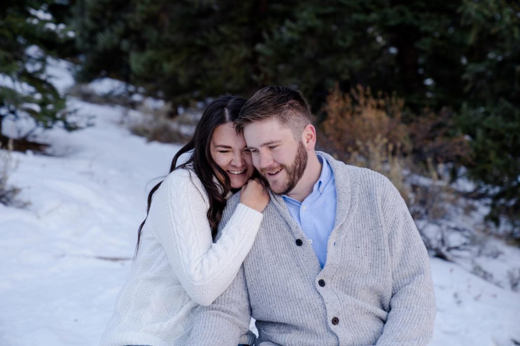engaged couple embrace in the snow