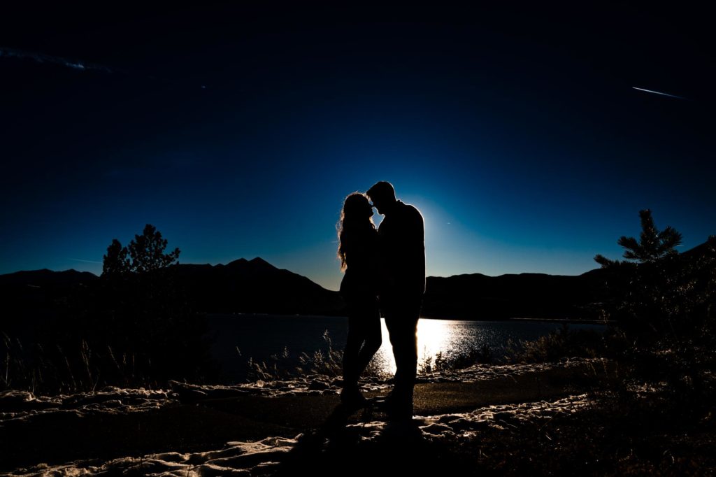 couple poses for winter engagement photos in Rocky Mountains