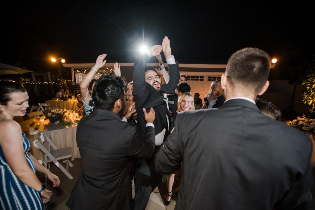 groomsmen dance at outdoor reception