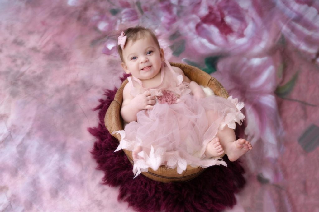 six month old baby poses in photography studio