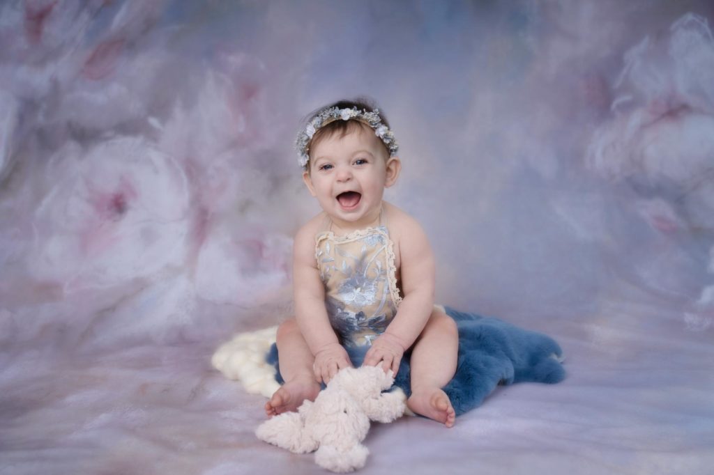 blue eyed baby poses in photography studio