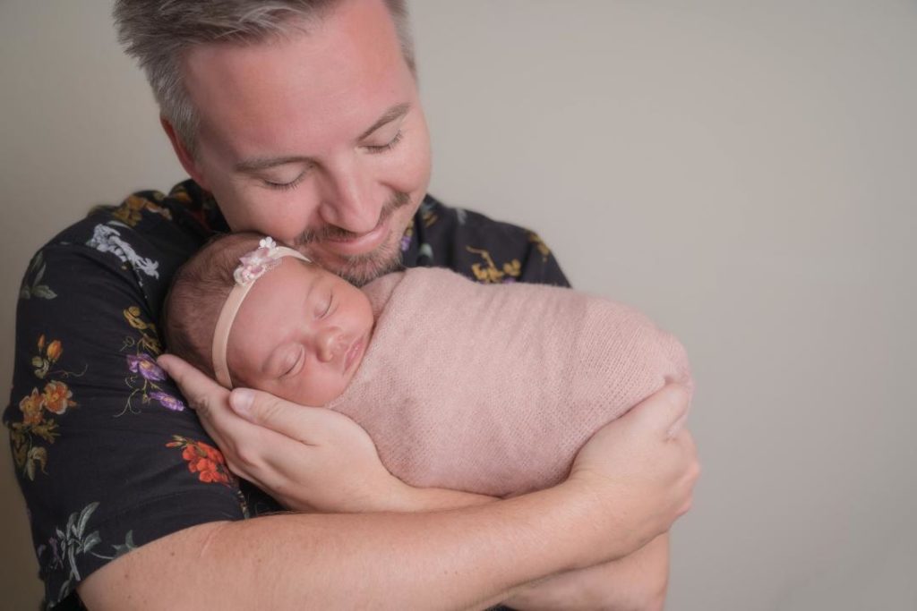 father holds newborn girl