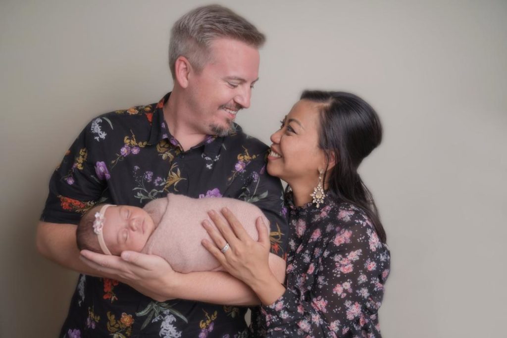 parents hold newborn baby