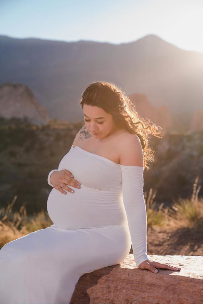 Pregnant woman in white dress at Garden of the Gods