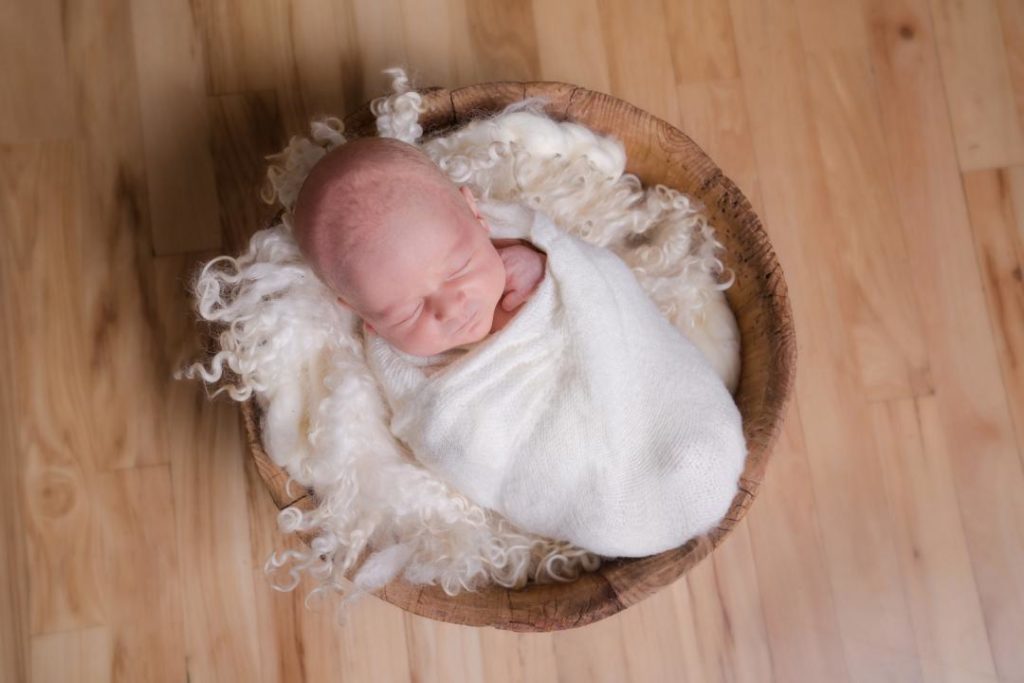 baby boy in wooden bucket newborn photos