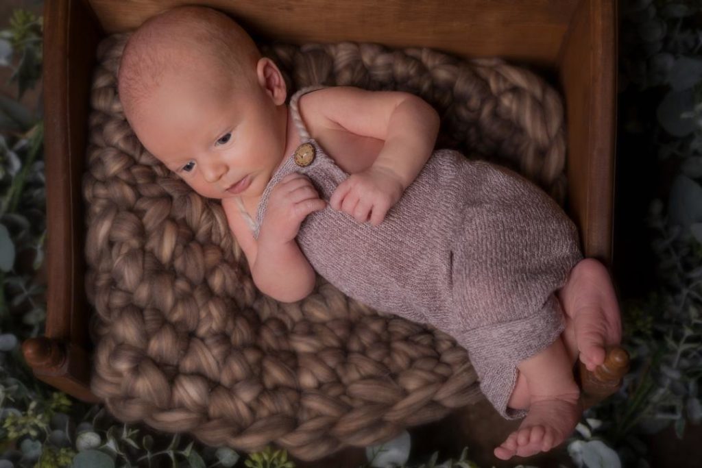 baby newborn photo in a mini crib